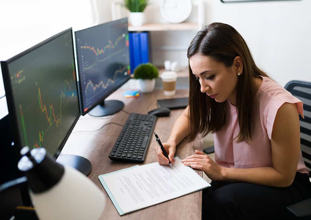 Trading Discipline for Day Traders 4 Trader reviewing a futures trading plan on dual monitors to build trading discipline