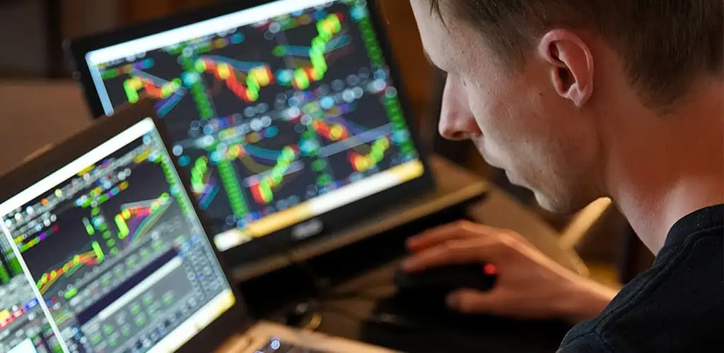 Passive vs Active Investing: Which Path Builds Wealth? 3 Trader reviewing a futures trading plan on dual monitors to build trading discipline